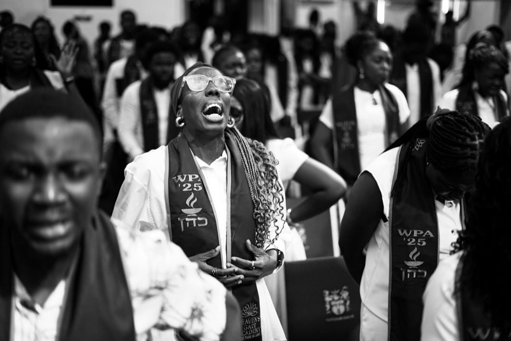 A graduate in prayer at the Workplace Altar ’25 ceremony